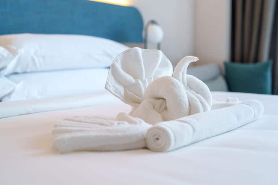 Linen change with swan shape towels on bed