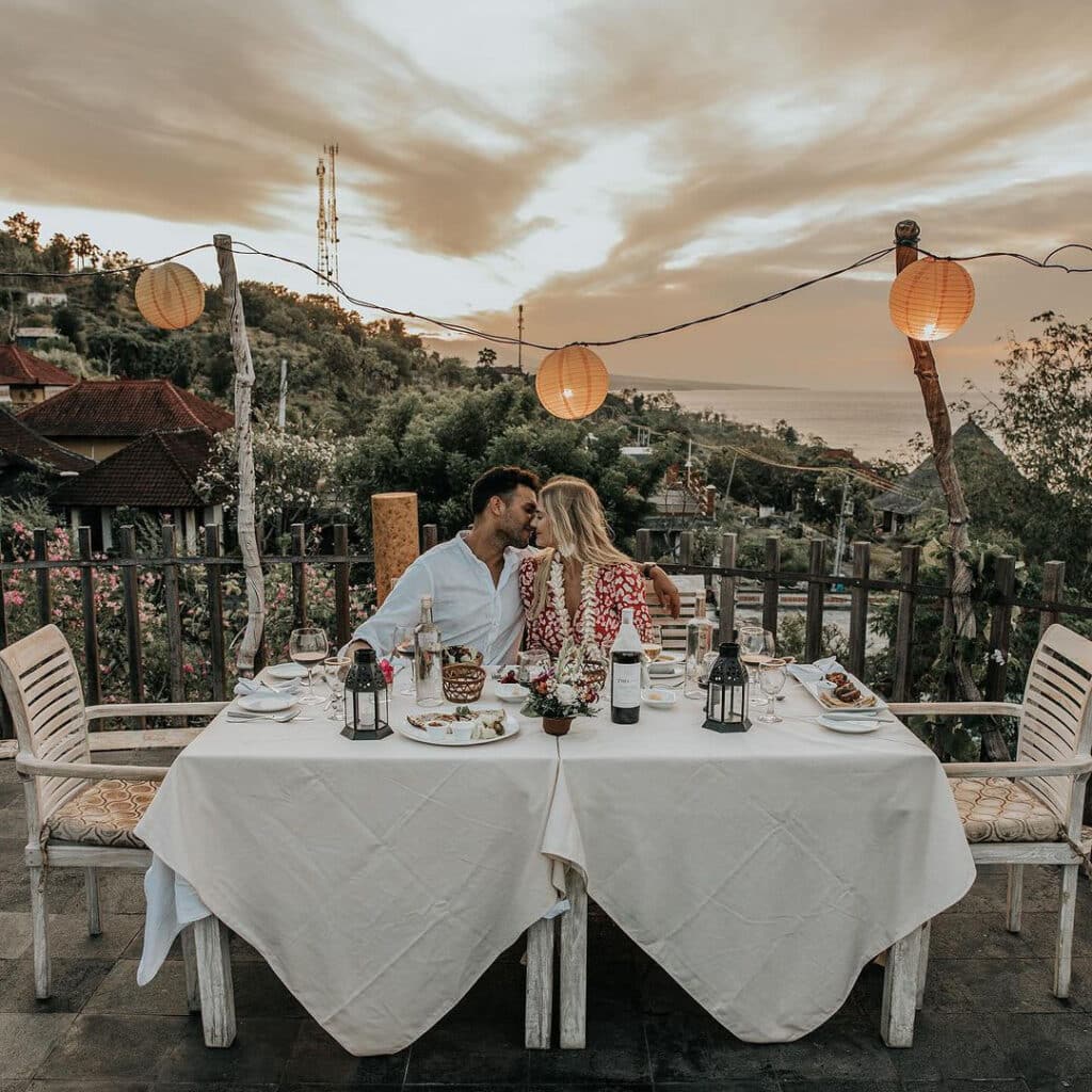 Couple eating fine dining food at the Safka Restaurant and Terrace in Amed Beach Bali.