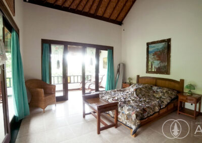 Guest bedroom with wooden furniture in traditional Balinese house in Amed