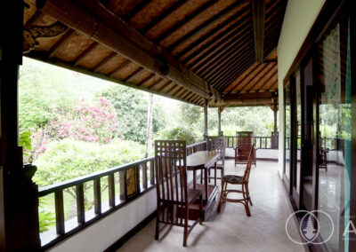 Teak wooden chairs on the outdoor balcony of a beachfront villa for sale in Amed.