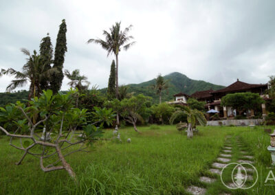 View towards a large Balinese villa in Amed with tropical hills in the background