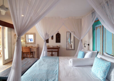 Bed with sky blue pillows and blue wood headrest