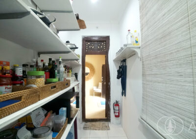 Pantry storage room with cooking ingredients a Balinese wooden doorway