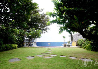 Garden of a beachfront house in Amed with tropical trees looking towards the Bali Sea