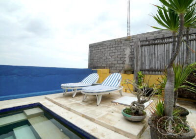 Sun beds next to the swimming pool for a beach front house in Amed.