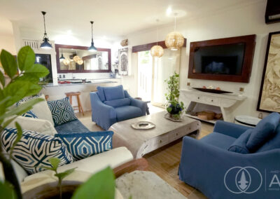 TV area with seating and wooden tables in a beachfront house for sale in Amed