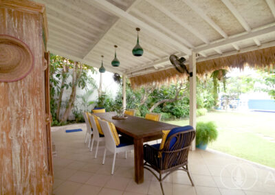 Outdoor seating under a covered terrance around a teak wooden table